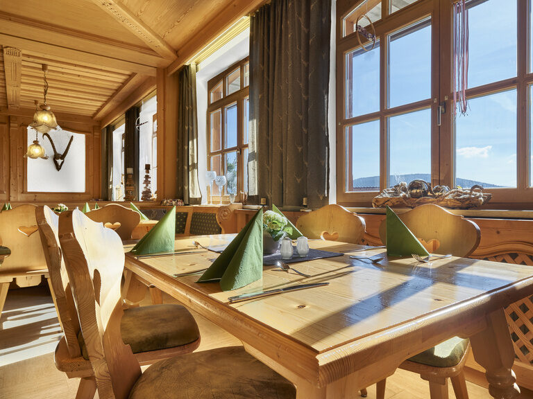 In der rustikal eingerichteten Gaststube der Pension Kilger verbinden sich große Fenster mit schöner Aussicht und gemütlich-bayerischem Flair.